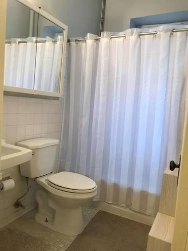 A white toilet sits next to a white sink in a bathroom.