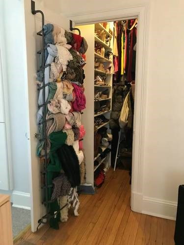 A hallway with a rack of clothes and a doorway.
