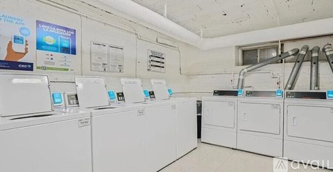 A row of washing machines are lined up in a laundromat.