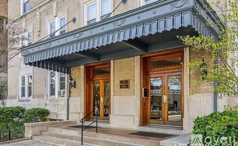 A building with a black awning and a brown door.