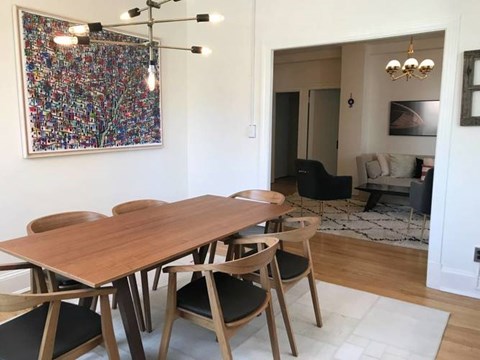 A dining room with a large table and chairs.
