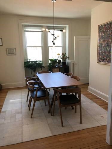 A dining room with a table and chairs.