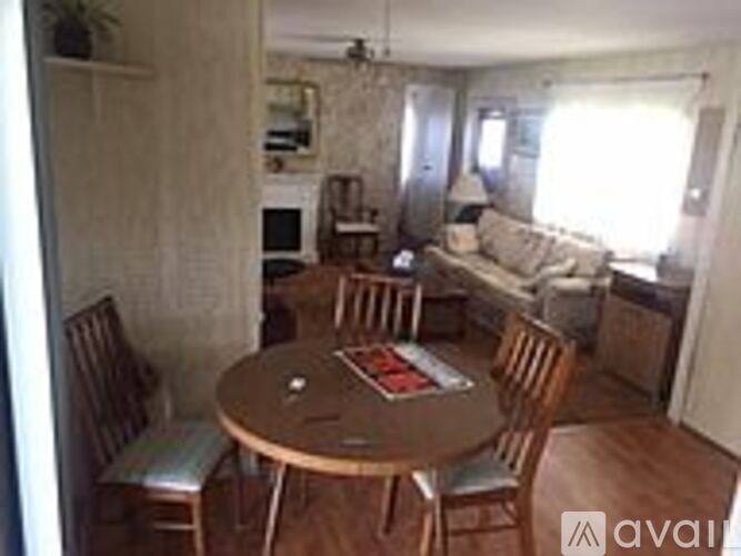 A living room with a couch, chairs, and a dining table.