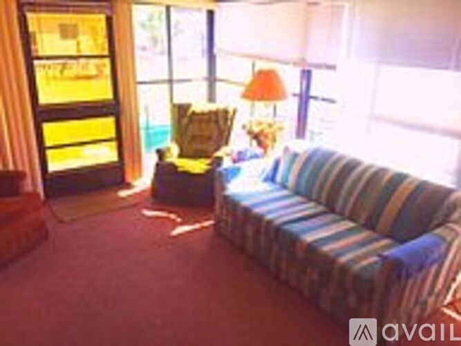 A living room with a striped couch and a chair.