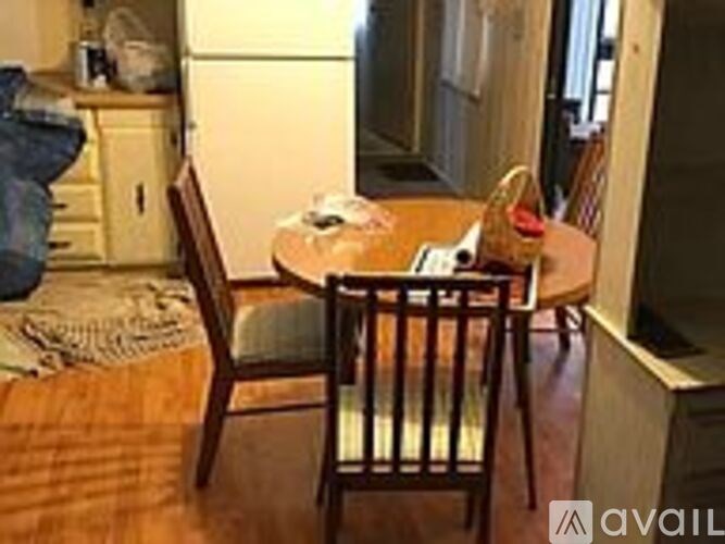 A wooden dining table with two chairs and a tablecloth.