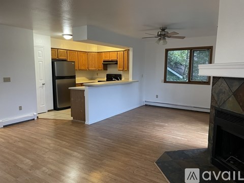 A kitchen with wooden cabinets and a black refrigerator.