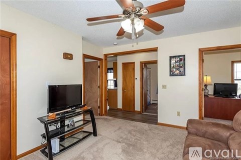 A living room with a television and a fan.