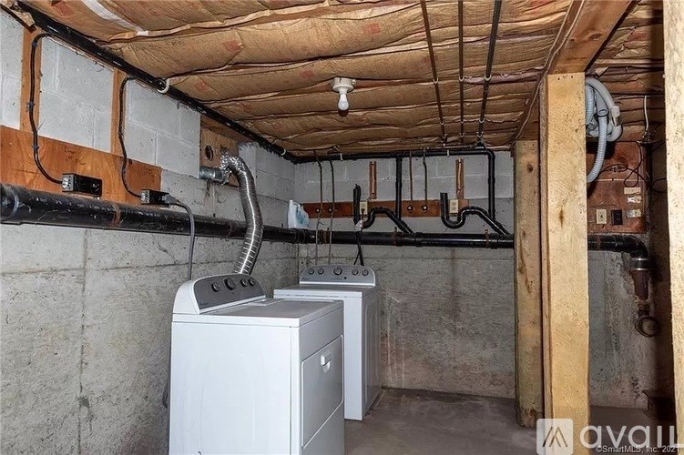 A room with a wall of pipes and a furnace.