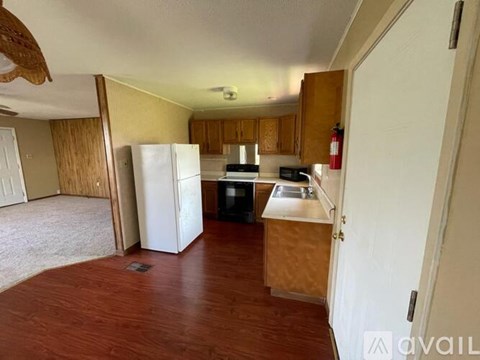 A kitchen with a white refrigerator and wooden cabinets.