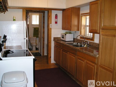 A kitchen with wooden cabinets and a white refrigerator.