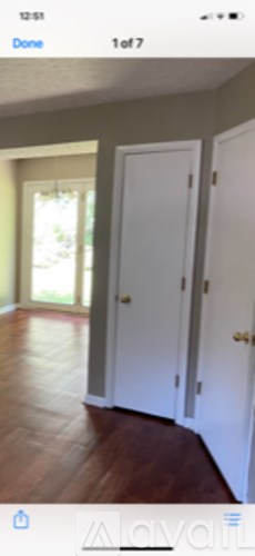 A room with a white door and wooden floor.