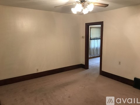 A room with a ceiling fan and a door leading outside.