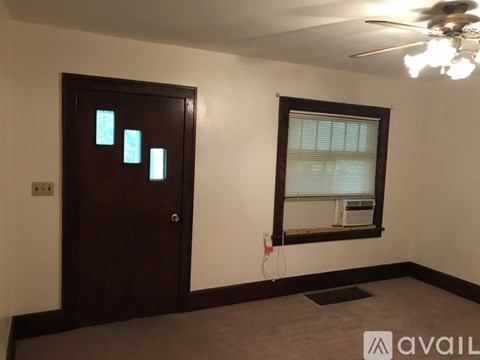 A room with a brown door and a window with blinds.