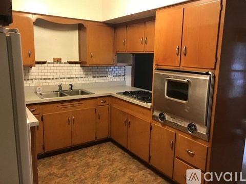 A kitchen with wooden cabinets and a stainless steel oven.
