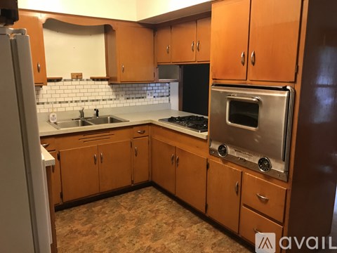 A kitchen with wooden cabinets and a stainless steel oven.