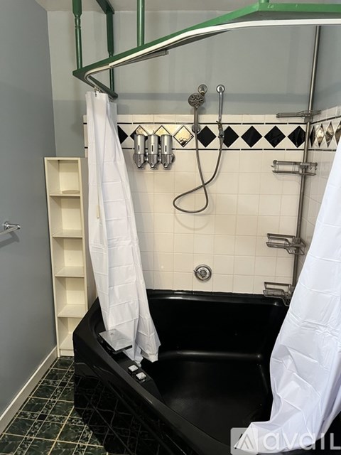 A bathroom with a toilet, a sink and a towel ring on the wall.