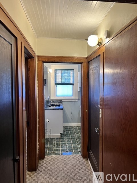 A room with a wooden door and a window with curtains.