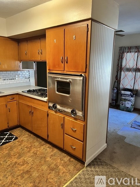 A kitchen with wooden cabinets and a white fridge.