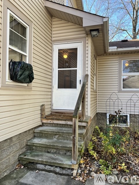 A house with a white door and a window with a black bag hanging on the wall.