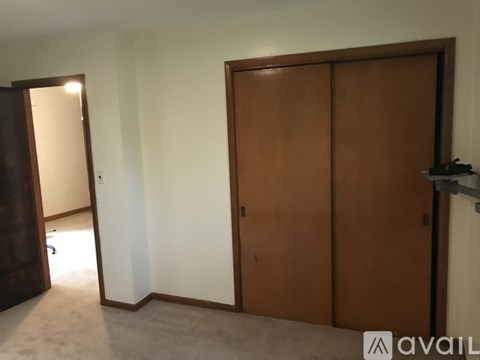 A room with a brown door and a mirror on the wall.