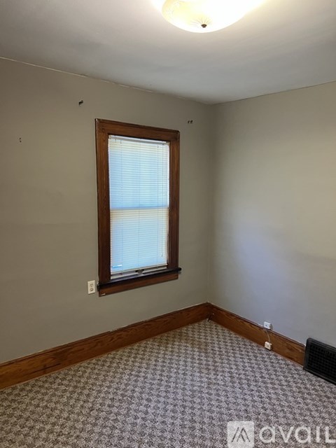 A room with a window and a carpet on the floor.