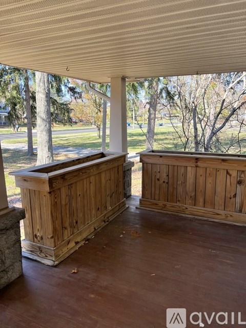 A wooden bench sits under a covered porch.