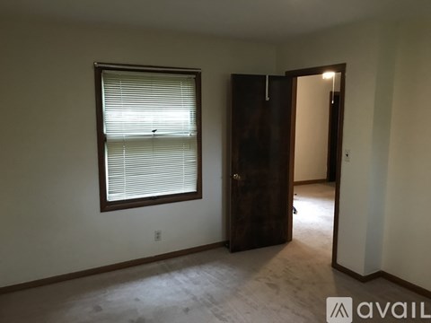 A room with a window and a wooden door.