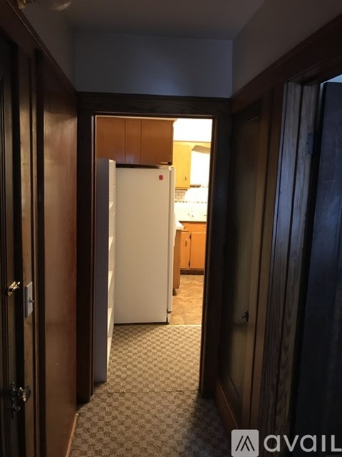 A hallway with a white door at the end.