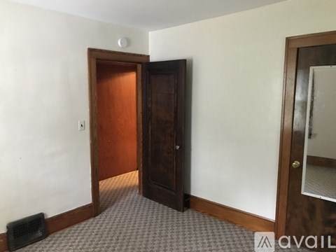 A room with a brown door and a carpeted floor.