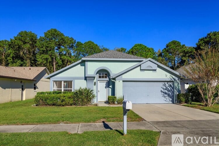 A blue house with a white garage door and a mailbox in front.