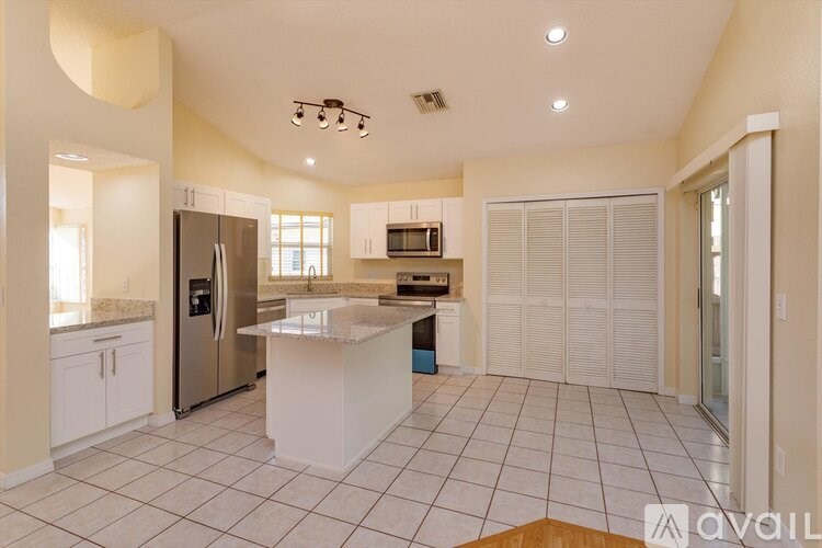A kitchen with a refrigerator, microwave, and oven.