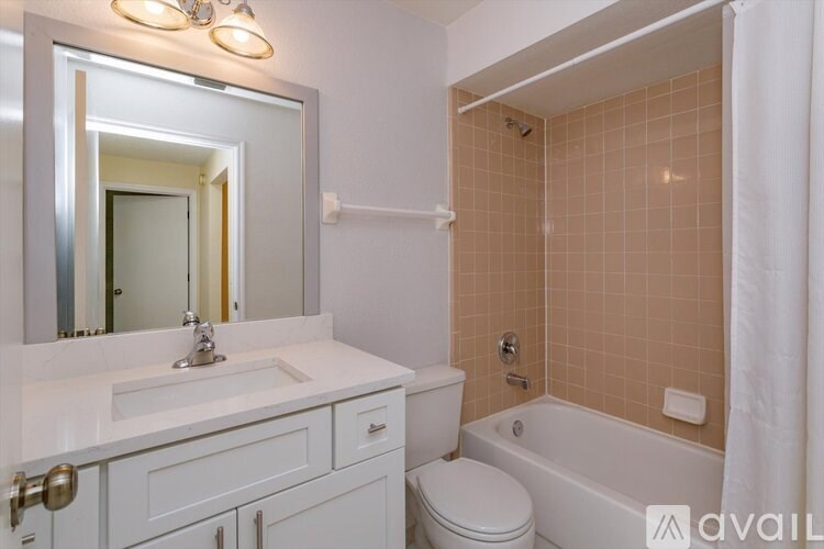 A bathroom with a white sink and toilet.