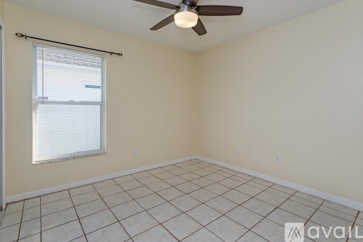 A room with a ceiling fan and tiled floor.