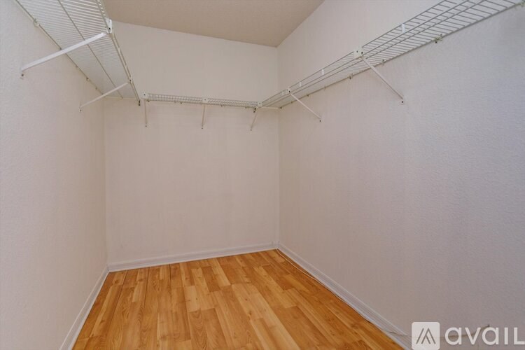 Empty room with white walls and wooden floor.