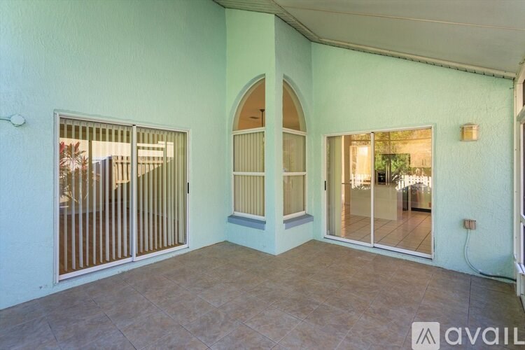 A room with a sliding glass door and a large arched window.