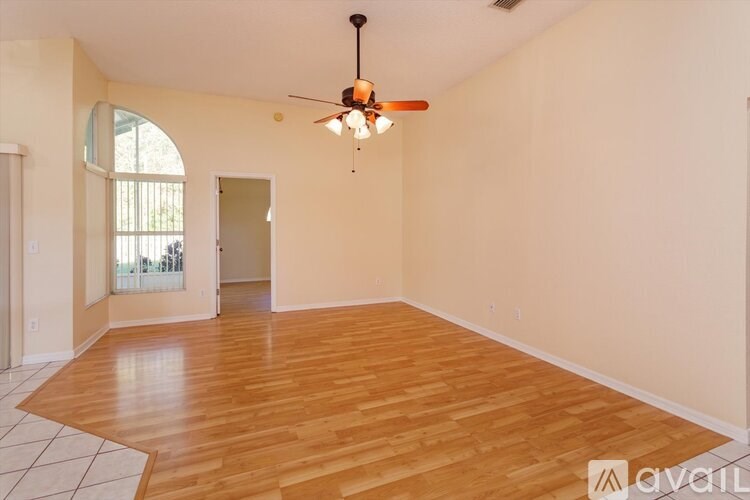 A room with wooden flooring and a ceiling fan.