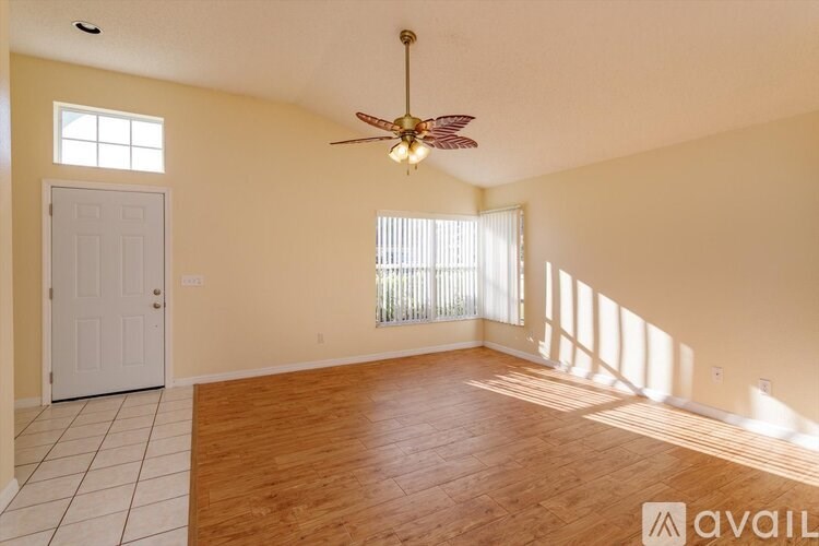 A room with a fan, a door, and a window with blinds.