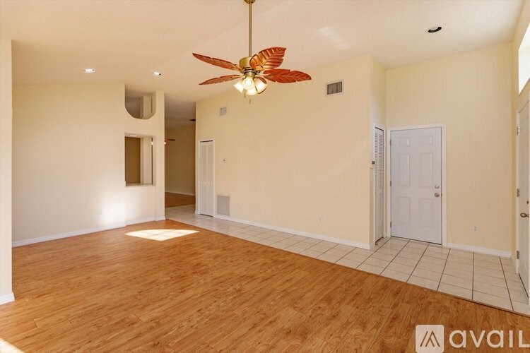 A room with a wooden floor and a ceiling fan.