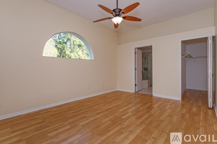 A room with wooden flooring and a ceiling fan.