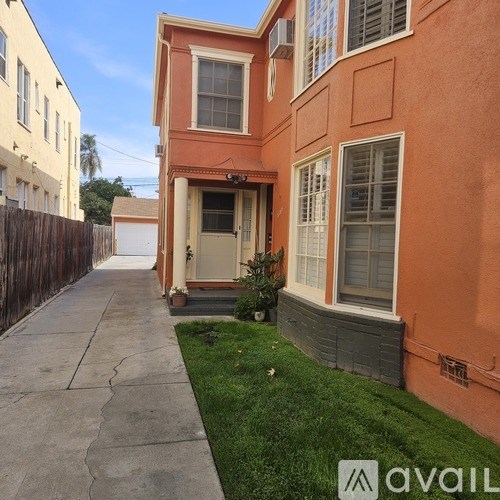 A house with a brown fence and a green lawn.