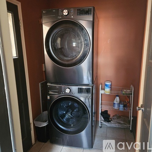 A stack of two front loading washing machines in a laundry room.