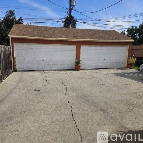 A two-car garage with a brown roof and white garage doors.