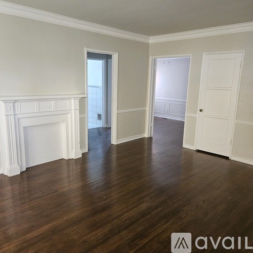 A room with a fireplace and wooden floors.