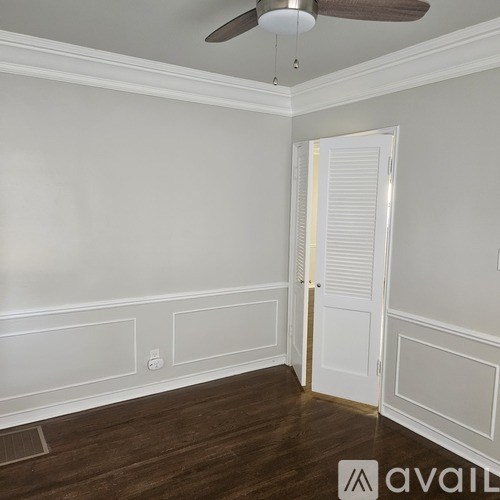 A room with a ceiling fan and a door.