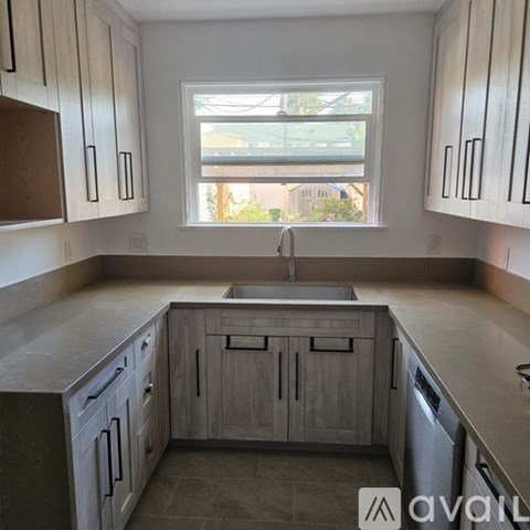 A kitchen with wooden cabinets and a window.