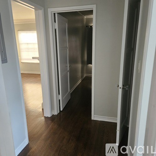 A hallway with a door on the right and a window in the distance.