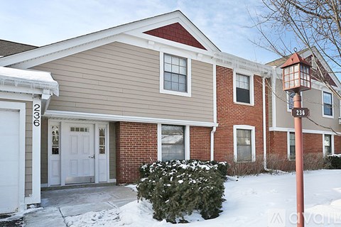 A house with a red brick wall and a white door.