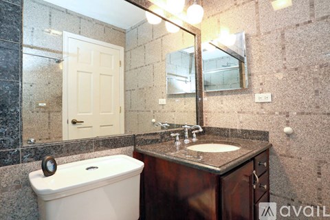 A bathroom with a white toilet, a sink, and a mirror.