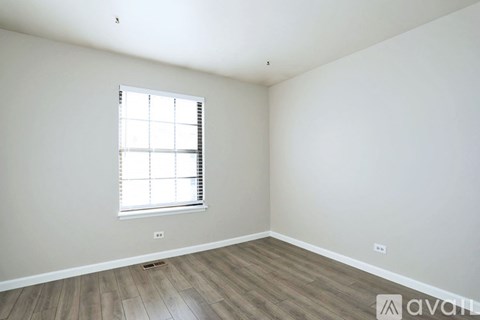 A room with a window and wooden flooring.