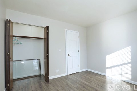A room with a white door and a glass wardrobe.